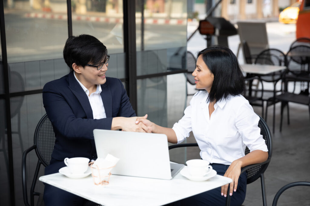 Two professionals shaking hands during a successful face-to-face marketing discussion.