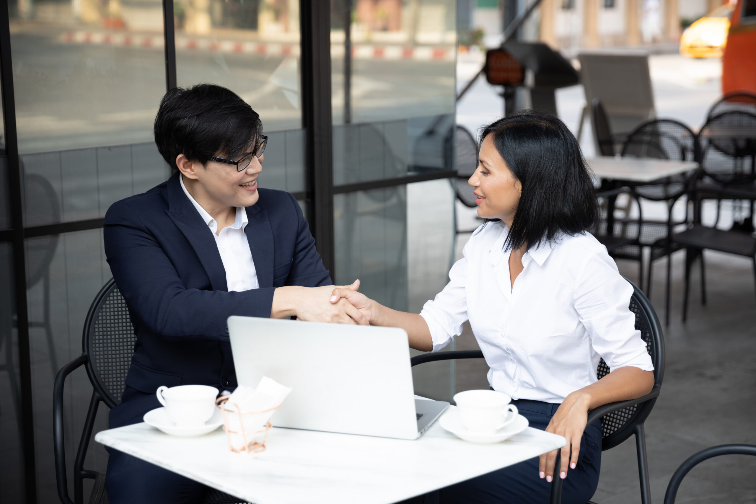 Two professionals shaking hands during a successful face-to-face marketing discussion.
