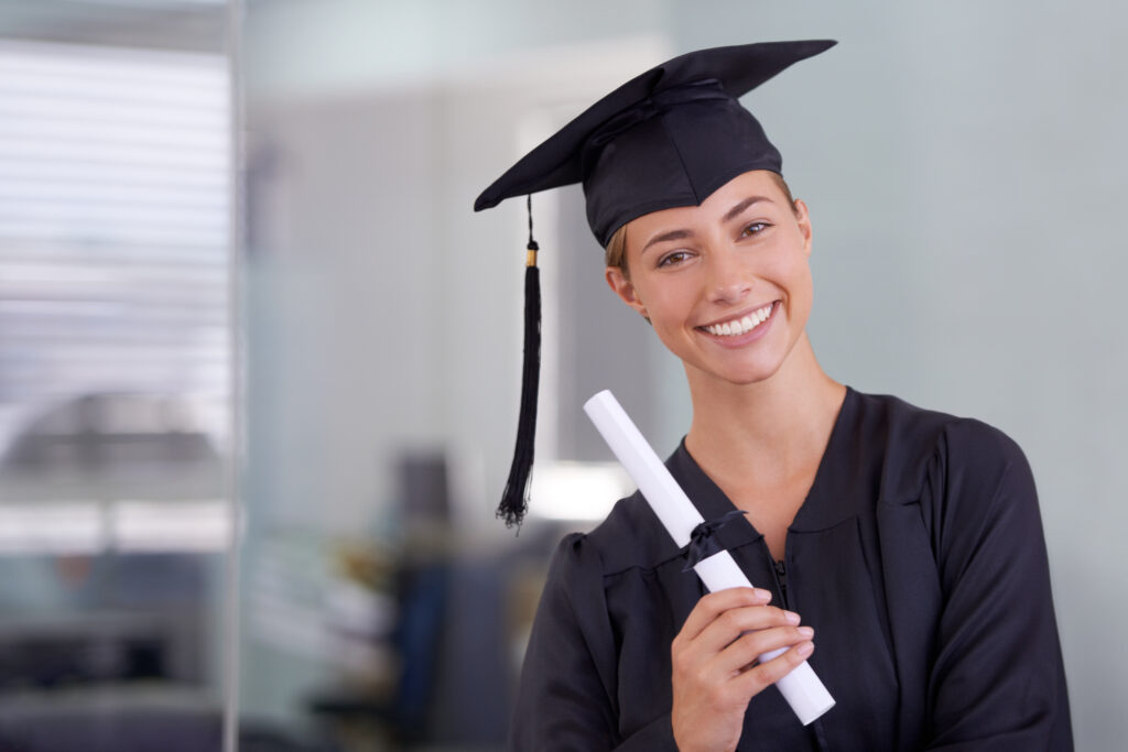 Close-up of a proud new grad holding her diploma, representing high hopes in job opportunities for new graduates.